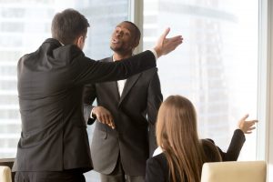 Formation gestion des conflits en entreprise : Trois collègues en costume en désaccord animé lors d’une réunion professionnelle dans un bureau moderne