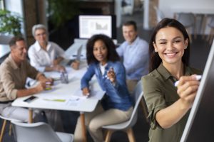 “Formation en communication interpersonnelle : une collaboratrice anime un atelier interactif devant une équipe engagée.