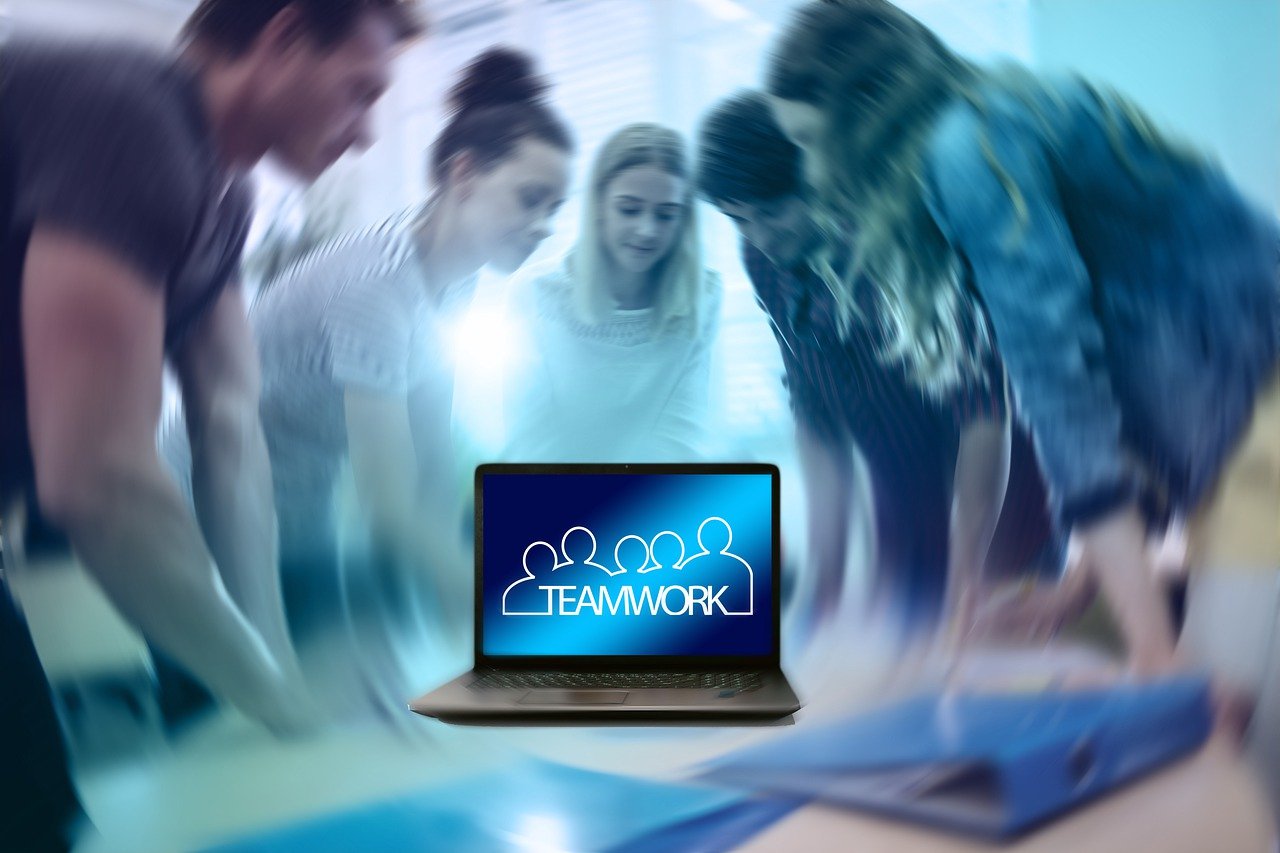 Équipe en discussion autour d’un ordinateur illustrant une formation en gestion des conflits en entreprise"