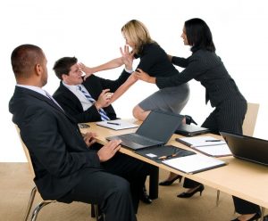 Employés en réunion d’entreprise confrontés à une situation de tension, illustrant la gestion des conflits au travail.