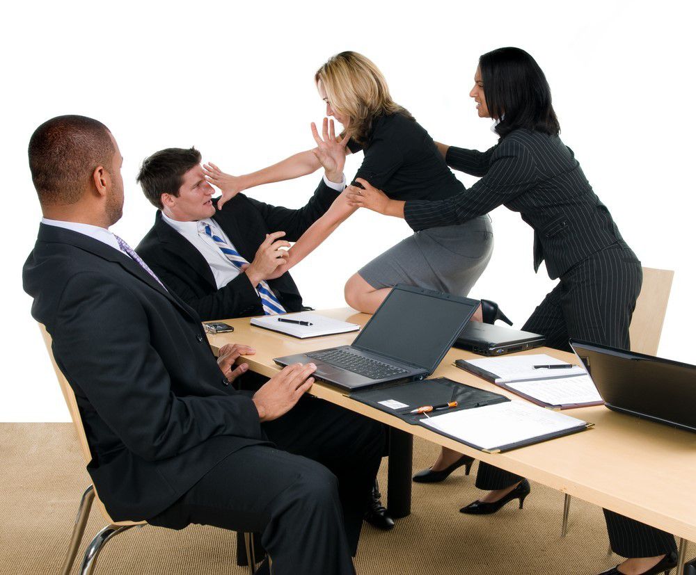 Employés en réunion d’entreprise confrontés à une situation de tension, illustrant la gestion des conflits au travail.