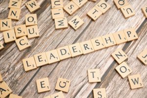 Mot “leadership” formé avec des lettres de Scrabble sur un fond en bois, illustrant la construction et la réflexion du leadership émotionnel.